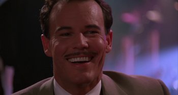 Movie still from “A Low Down Dirty Shame” (1994), directed by Keenen Ivory Wayans – A person wearing a suit and smiling; Close Up shot, Low angle