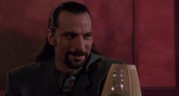 Movie still from “A Low Down Dirty Shame” (1994), directed by Keenen Ivory Wayans – A man with long black hair sitting in front of a lamp; Close Up shot, Low angle