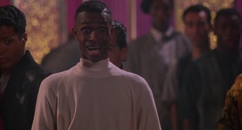 Movie still from “A Low Down Dirty Shame” (1994), directed by Keenen Ivory Wayans – A man standing in front of a group of people; Close Up shot, Low angle