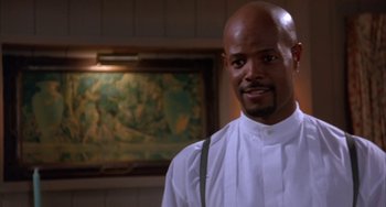 Movie still from “A Low Down Dirty Shame” (1994), directed by Keenen Ivory Wayans – A man in a white shirt is standing in front of a painting; Close Up shot, Low angle