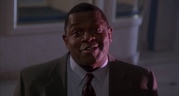 Movie still from “A Low Down Dirty Shame” (1994), directed by Keenen Ivory Wayans – A person wearing a suit and tie; Close Up shot, Low angle