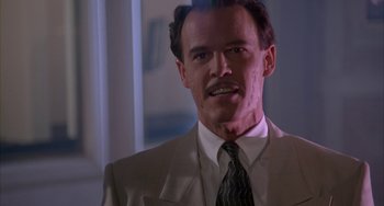 Movie still from “A Low Down Dirty Shame” (1994), directed by Keenen Ivory Wayans – A man in a suit and tie smiling for the camera; Close Up shot, Low angle