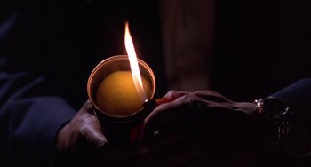 Movie still from “A Low Down Dirty Shame” (1994), directed by Keenen Ivory Wayans – A person is holding a cup with a lit candle in it; Extreme Close Up shot, Low angle