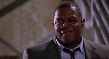 Movie still from “A Low Down Dirty Shame” (1994), directed by Keenen Ivory Wayans – A person wearing a suit and tie; Close Up shot, Low angle