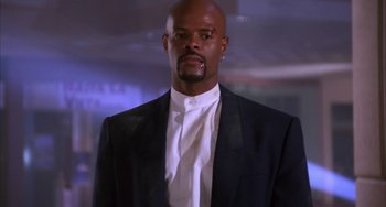 Movie still from “A Low Down Dirty Shame” (1994), directed by Keenen Ivory Wayans – A man in a black suit and a white shirt; Close Up shot, Low angle