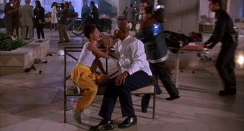 Movie still from “A Low Down Dirty Shame” (1994), directed by Keenen Ivory Wayans – A man and a woman sitting on a bench in a room; Medium shot, Low angle