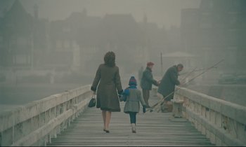 Movie still from “A Man and a Woman” (1966), directed by Claude Lelouch – Two women and a child walking across a bridge in the fog; Wide shot, Low angle