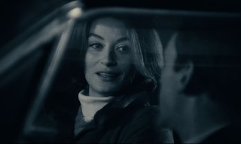 Movie still from “A Man and a Woman” (1966), directed by Claude Lelouch – A black and white photo of a woman in the back of a car; Close Up shot, Over the shoulder angle