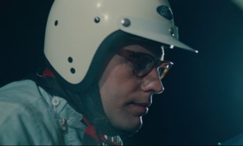 Movie still from “A Man and a Woman” (1966), directed by Claude Lelouch – A person wearing a helmet; Close Up shot, Low angle