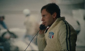 Movie still from “A Man and a Woman” (1966), directed by Claude Lelouch – A man talking on a phone while wearing a white jacket; Close Up shot, High angle