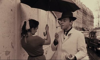 Movie still from “A Man and a Woman” (1966), directed by Claude Lelouch – A man holding an umbrella over a woman's face; Medium shot, Low angle