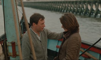Movie still from “A Man and a Woman” (1966), directed by Claude Lelouch – A man and a woman standing next to each other on a boat; Medium shot, Over the shoulder angle