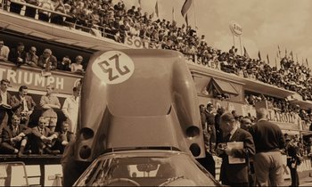 Movie still from “A Man and a Woman” (1966), directed by Claude Lelouch – An old photo of a race car in front of a crowd; Wide shot, Low angle