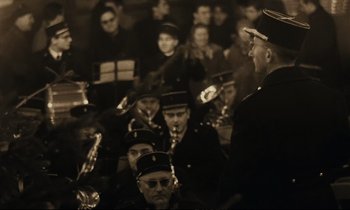 Movie still from “A Man and a Woman” (1966), directed by Claude Lelouch – A group of men in uniform are gathered together; Medium shot, High angle