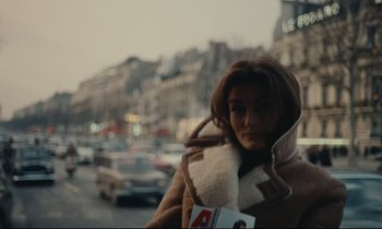 Movie still from “A Man and a Woman” (1966), directed by Claude Lelouch – A woman is standing in the middle of the street; Close Up shot, High angle
