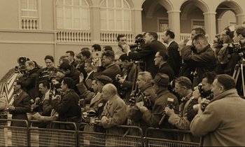 Movie still from “A Man and a Woman” (1966), directed by Claude Lelouch – A group of people sitting in a crowd taking pictures; Wide shot, High angle