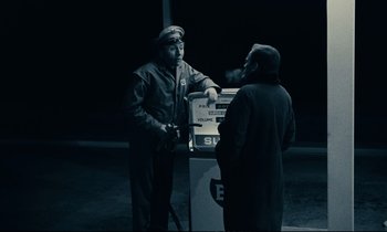 Movie still from “A Man and a Woman” (1966), directed by Claude Lelouch – Two men standing next to each other in front of a parking meter; Medium shot, High angle