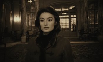 Movie still from “A Man and a Woman” (1966), directed by Claude Lelouch – A black and white photo of a woman in a coat; Medium shot, Low angle