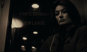 Movie still from “A Man and a Woman” (1966), directed by Claude Lelouch – A woman standing in front of a lit up sign; Close Up shot, Low angle