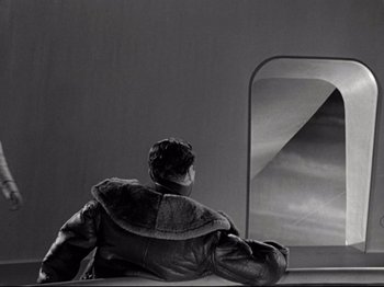 Movie still from “A Matter of Life and Death” (1946), directed by Emeric Pressburger – A man sitting on a ledge looking out a window; Medium shot, Low angle