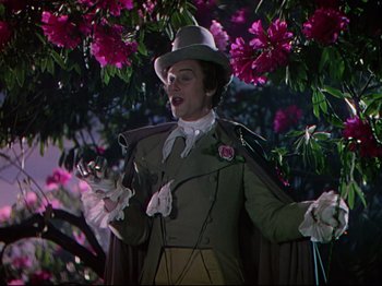 Movie still from “A Matter of Life and Death” (1946), directed by Emeric Pressburger – A man in a hat and a green jacket standing next to a tree; Medium shot, Low angle