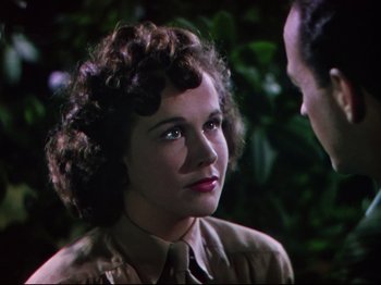 Movie still from “A Matter of Life and Death” (1946), directed by Emeric Pressburger – A young woman with curly brown hair wearing a tie; Close Up shot, Over the shoulder angle