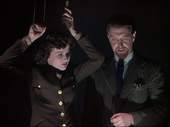 Movie still from “A Matter of Life and Death” (1946), directed by Emeric Pressburger – A man and a woman are holding on to a string; Medium shot, Low angle