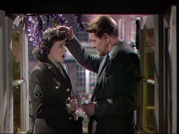 Movie still from “A Matter of Life and Death” (1946), directed by Emeric Pressburger – A man and a woman in military uniforms are looking at each other's hair; Medium shot, Over the shoulder angle