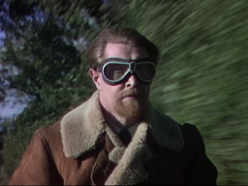 Movie still from “A Matter of Life and Death” (1946), directed by Emeric Pressburger – A man with a beard wearing sunglasses and a jacket; Medium shot, Over the shoulder angle