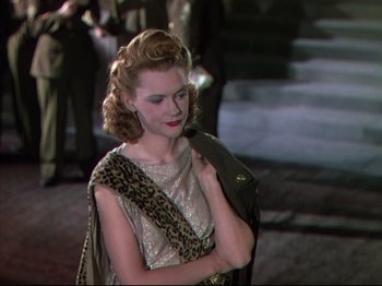 Movie still from “A Matter of Life and Death” (1946), directed by Emeric Pressburger – A woman in a leopard print dress and a brown jacket; Medium shot, Over the shoulder angle