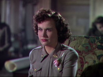 Movie still from “A Matter of Life and Death” (1946), directed by Emeric Pressburger – A woman sitting in a chair wearing a military uniform; Close Up shot, Over the shoulder angle