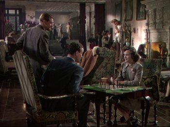 Movie still from “A Matter of Life and Death” (1946), directed by Emeric Pressburger – A group of people sitting around a table playing chess; Wide shot, High angle