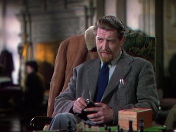 Movie still from “A Matter of Life and Death” (1946), directed by Emeric Pressburger – A man in a suit and tie holding a cell phone; Medium shot, Over the shoulder angle
