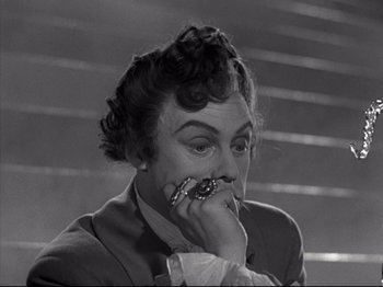 Movie still from “A Matter of Life and Death” (1946), directed by Emeric Pressburger – An old photo of a woman with a ring in her mouth; Close Up shot, High angle