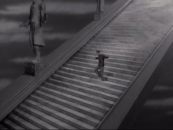 Movie still from “A Matter of Life and Death” (1946), directed by Emeric Pressburger – A man riding a skateboard down the side of a set of stairs; Extreme Wide shot, High angle