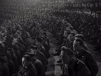 Movie still from “A Matter of Life and Death” (1946), directed by Emeric Pressburger – A large group of men sitting in a room together; Extreme Wide shot, High angle