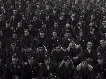 Movie still from “A Matter of Life and Death” (1946), directed by Emeric Pressburger – A large group of men in uniform sitting in a stadium; Wide shot, High angle