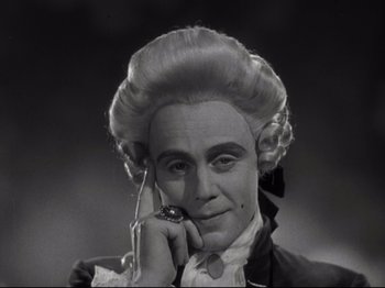 Movie still from “A Matter of Life and Death” (1946), directed by Emeric Pressburger – A man in a wig is holding a cell phone to his ear; Close Up shot, High angle