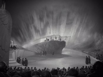 Movie still from “A Matter of Life and Death” (1946), directed by Emeric Pressburger – A group of people standing in front of a stage; Extreme Wide shot, High angle