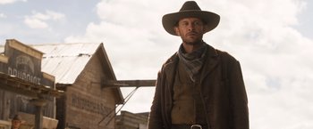 Movie still from “A Million Ways to Die in the West” (2014), directed by Seth MacFarlane – A man wearing a cowboy hat and a brown jacket; Medium shot, Low angle