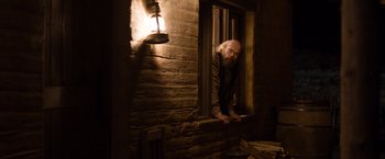 Movie still from “A Million Ways to Die in the West” (2014), directed by Seth MacFarlane – An old man leaning out of a window at night; Medium shot, Low angle