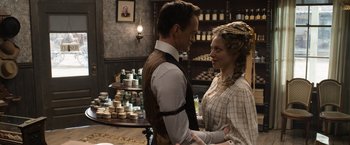 Movie still from “A Million Ways to Die in the West” (2014), directed by Seth MacFarlane – A man and a woman standing next to each other in a room; Medium shot, Over the shoulder angle