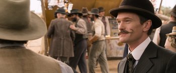 Movie still from “A Million Ways to Die in the West” (2014), directed by Seth MacFarlane – A group of men standing in a line wearing hats and ties; Close Up shot, Over the shoulder angle
