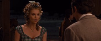 Movie still from “A Million Ways to Die in the West” (2014), directed by Seth MacFarlane – A woman in a plaid dress with a bunch of hair in her hair; Close Up shot, Over the shoulder angle