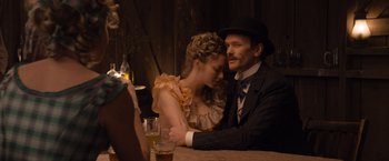 Movie still from “A Million Ways to Die in the West” (2014), directed by Seth MacFarlane – A man and a woman sitting at a table with drinks; Medium shot, Over the shoulder angle