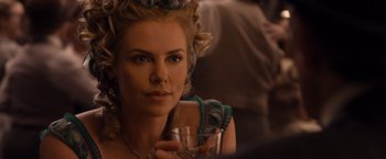 Movie still from “A Million Ways to Die in the West” (2014), directed by Seth MacFarlane – A beautiful woman holding a wine glass in a room; Close Up shot, Over the shoulder angle