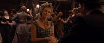 Movie still from “A Million Ways to Die in the West” (2014), directed by Seth MacFarlane – A woman sitting in front of a group of people; Medium shot, Over the shoulder angle