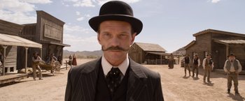 Movie still from “A Million Ways to Die in the West” (2014), directed by Seth MacFarlane – A man in a top hat and a suit; Close Up shot, Low angle