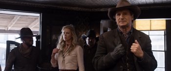 Movie still from “A Million Ways to Die in the West” (2014), directed by Seth MacFarlane – A group of people standing next to each other in a room; Medium shot, Over the shoulder angle