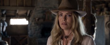 Movie still from “A Million Ways to Die in the West” (2014), directed by Seth MacFarlane – A woman wearing a cowboy hat in a room; Close Up shot, Over the shoulder angle